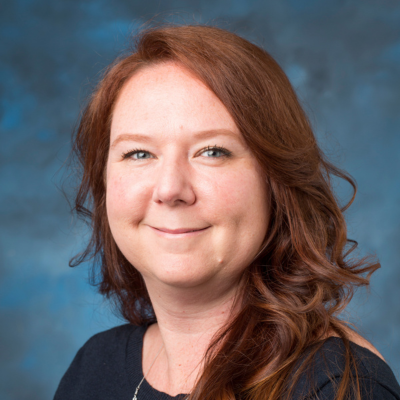 A headshot of Jennifer Belichesky-Larson on a blue background